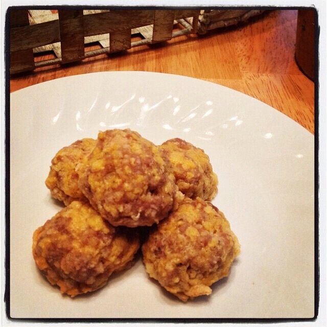 Homepage post card 4: Stack of five golden-brown sausage and cheese balls on a ridged white plate with a warm Instagram-style border
